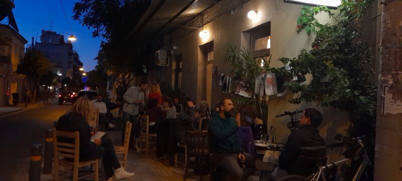 Lively terrace of a bar at night in a street of Metaxourghio in Athens